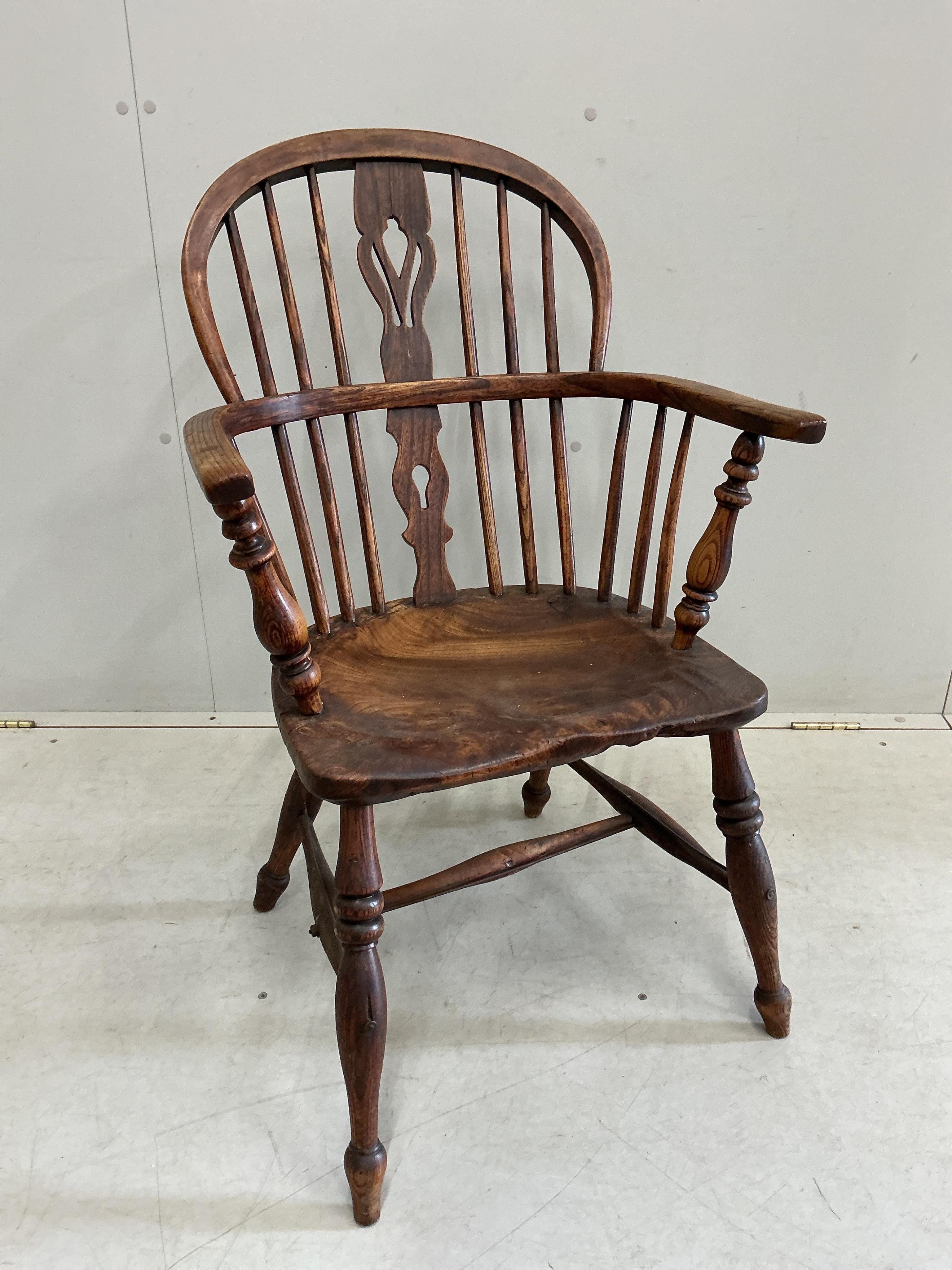 A mid 19th century Thames Valley elm and beech comb back Windsor elbow chair, width 55cm, depth 36cm, height 92cm